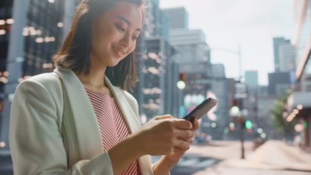 Japansk kvindelig bruger Smartphone på City Street – Stock-video