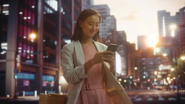 Japonês feminino usa smartphone no cidade no por do sol — Vídeo de Stock