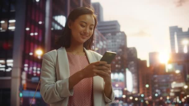Mujer japonesa utiliza Smartphone en la ciudad al atardecer — Vídeos de Stock