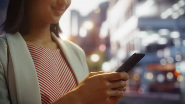 Japonês feminino usa smartphone no cidade no por do sol — Vídeo de Stock