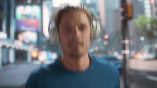 Mand jogging i hovedtelefoner på gaden – Stock-video