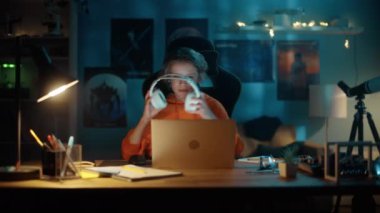 Kulaklıklı Genç Evde Dizüstü bilgisayar kullanıyor