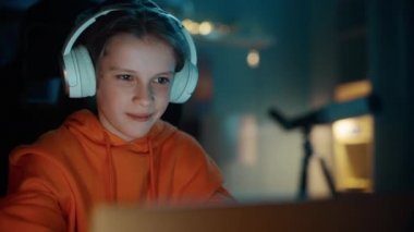 Kulaklıklı Genç Evde Dizüstü bilgisayar kullanıyor