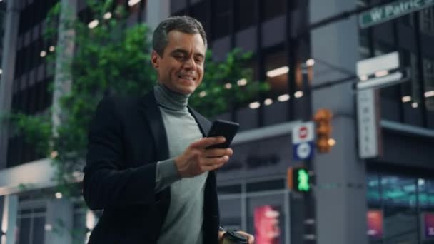 Homem bonito usa smartphone na rua da cidade — Vídeo de Stock