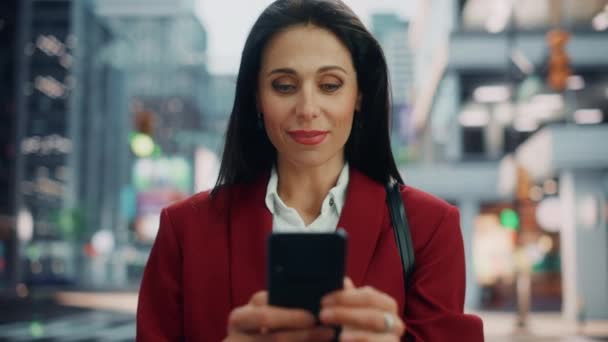 女性は街の路上でスマートフォンを使う — ストック動画