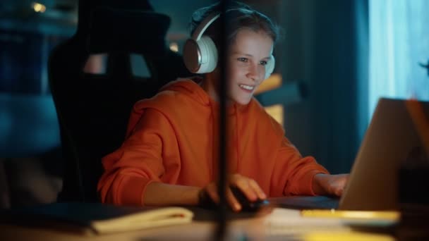 Jeune garçon dans les écouteurs en utilisant un ordinateur portable à la maison — Video