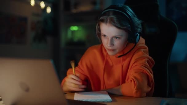 Ung pojke deltar online-klass på bärbar dator hemma — Stockvideo