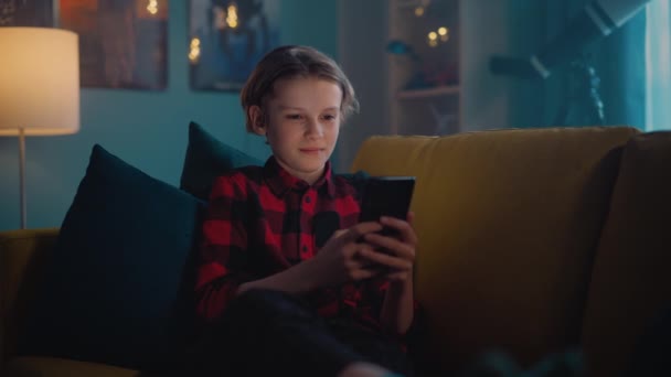 Młody chłopak w domu przy użyciu smartfona — Wideo stockowe