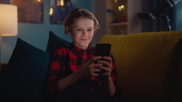 Niño usando el teléfono inteligente en casa — Vídeo de stock