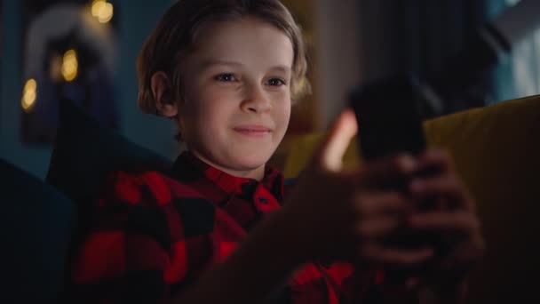 Niño usando el teléfono inteligente en casa — Vídeos de Stock