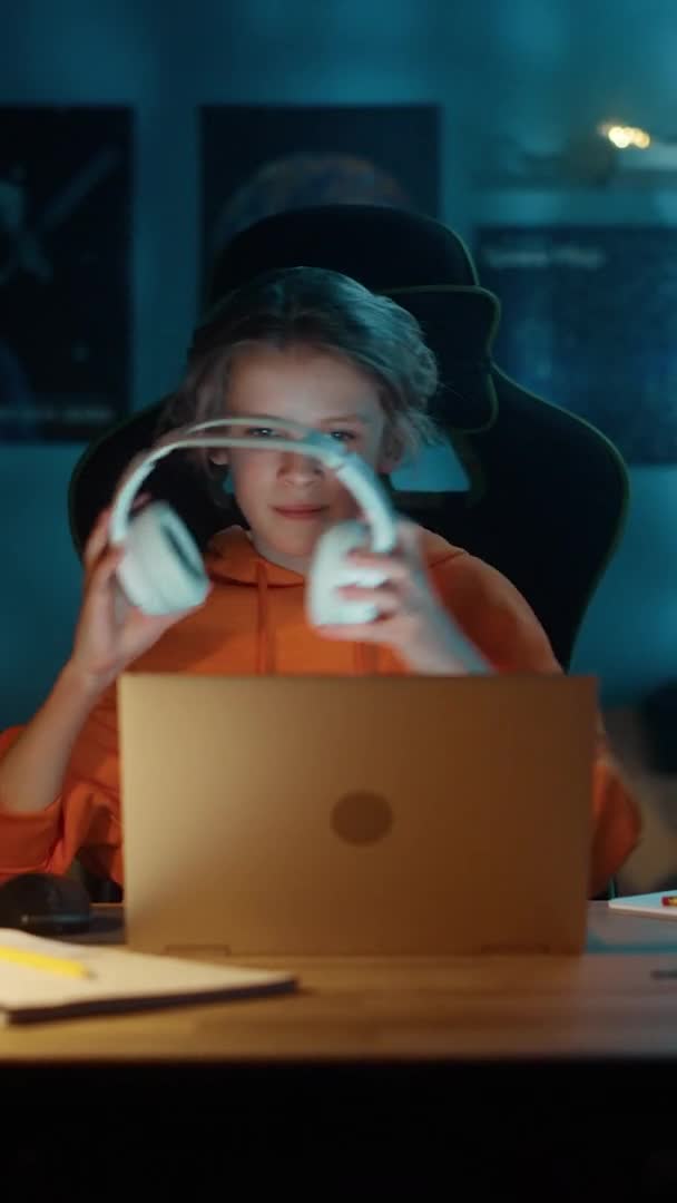 Retrato vertical de un niño joven usando una computadora portátil en casa — Vídeos de Stock