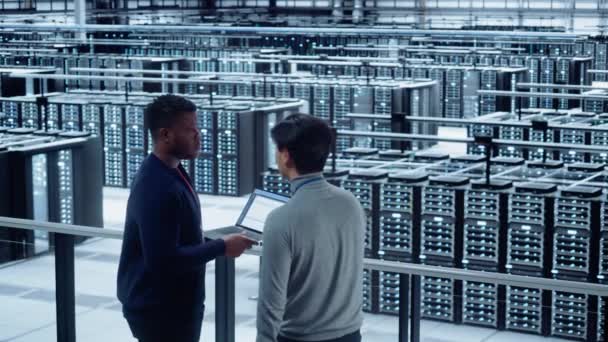 Dois especialistas de data center falam usar o computador portátil — Vídeo de Stock