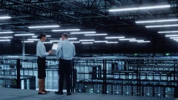 Due specialisti del data center parlano usano il computer portatile — Video Stock