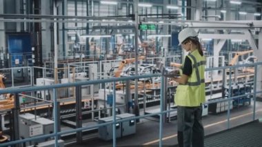 Araba fabrikasında dizüstü bilgisayarı olan kadın mühendis.