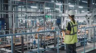 Araba fabrikasında dizüstü bilgisayarı olan kadın mühendis.