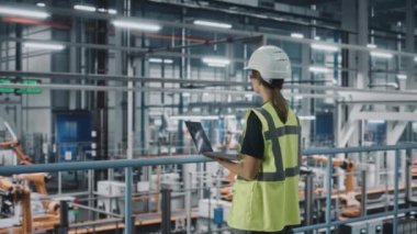 Araba fabrikasında dizüstü bilgisayarı olan kadın mühendis.