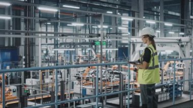 Araba fabrikasında dizüstü bilgisayarı olan kadın mühendis.