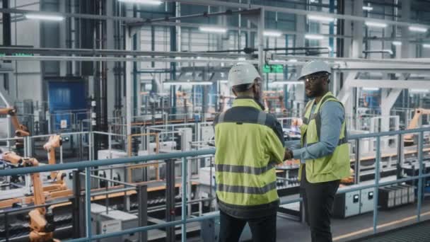 Industriële ingenieurs praten met behulp van Laptop in de autofabriek — Stockvideo