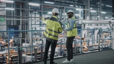 Araba fabrikasında bilgisayar kullanan Endüstri Mühendisleri konuşuyor.