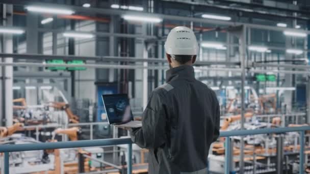 Manlig ingenjör med bärbar dator på bilfabriken — Stockvideo