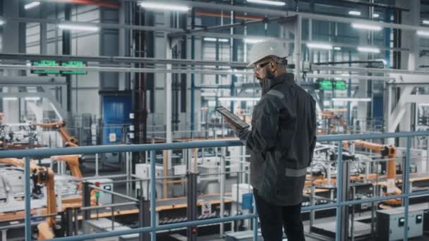 Ingeniero masculino con la tableta en la fábrica del coche — Vídeos de Stock