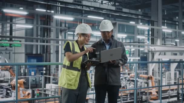 Engenheiros automotivos conversando usando tablet portátil na fábrica de carros — Vídeo de Stock