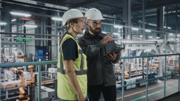 Ingenieros de automoción hablando con Tablet en la fábrica de automóviles — Vídeo de stock