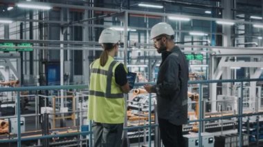 Araba fabrikasında bilgisayar kullanan Endüstri Mühendisleri konuşuyor.