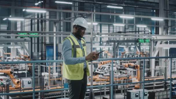 Muž inženýr s tabletem v továrně na automobily — Stock video