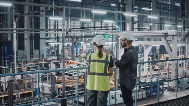 Ingegneri industriali parlando utilizzando il computer portatile in fabbrica di auto — Video Stock