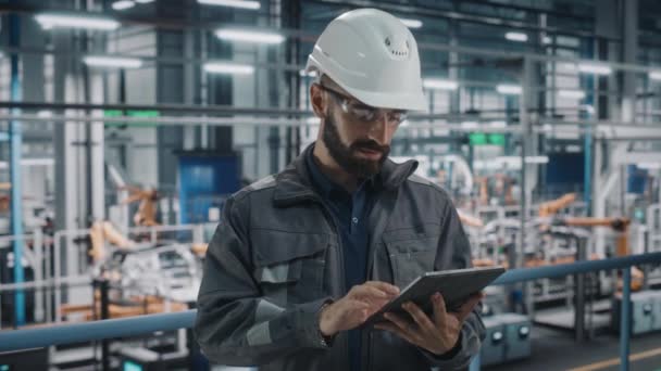 Ingeniero masculino con la tableta en la fábrica del coche — Vídeos de Stock