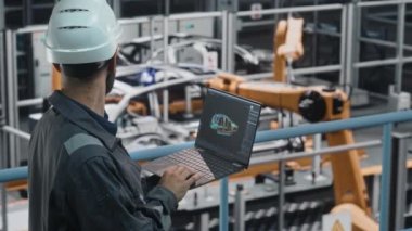 Araba fabrikasında CAD çizimi olan dizüstü bilgisayarı olan erkek mühendis.