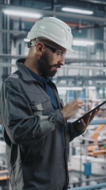 Dikey Portre Mühendisi Otomobil Fabrikasında Tablet üzerinde çalışıyor