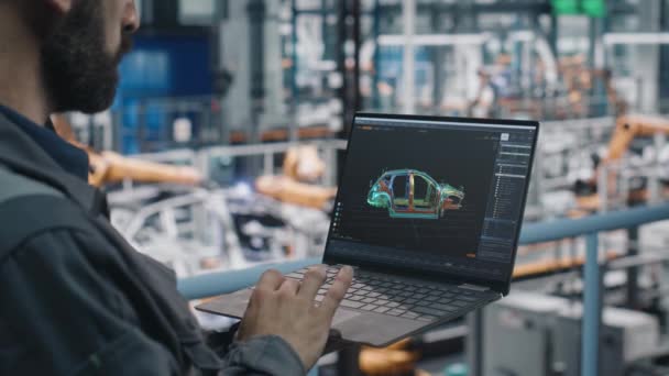 Инженер-мужчина работает над ноутбуком на автомобильном заводе — стоковое видео