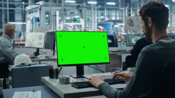 Инженеры используют зеленый экран компьютера на автомобильном заводе — стоковое видео