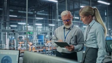 Araba Fabrikasında Erkek ve Kadın Mühendisler Tablet Bilgisayar kullanıyor