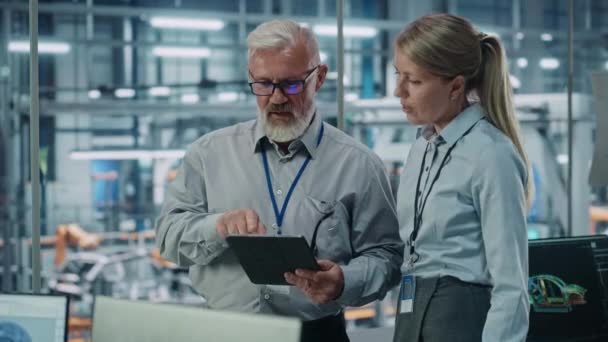 Engenheiros masculinos e femininos usando o Tablet Computer na fábrica de carros — Vídeo de Stock