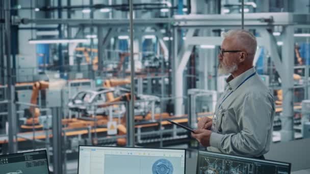 Muž inženýr pomocí tabletu počítače v továrně na automobily — Stock video