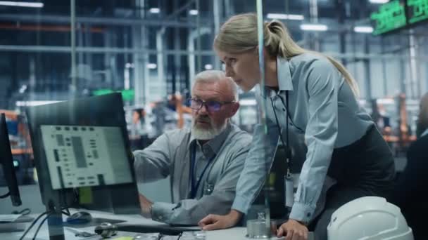 Dos ingenieros trabajando en la computadora en la fábrica de automóviles — Vídeos de Stock