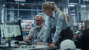 Araba fabrikasında Bilgisayar üzerine çalışan iki mühendis.