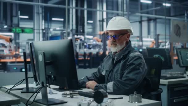 Ingenjör som arbetar med dator i bilfabriken — Stockvideo