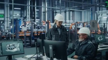 Araba fabrikasında Bilgisayar üzerine çalışan iki mühendis.