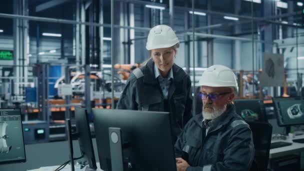 Két mérnök dolgozik a számítógépen az autógyárban — Stock videók