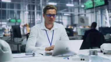 Otomotiv Fabrikasında Dizüstü bilgisayarda çalışan mühendis