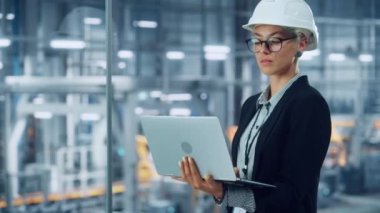 Araba fabrikasında dizüstü bilgisayarda çalışan kadın mühendisin portresi