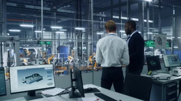 Δύο εργαζόμενοι Μιλώντας στο γραφείο μηχανικών στο εργοστάσιο αυτοκινήτων — Αρχείο Βίντεο