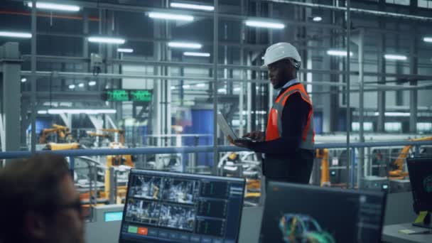Inženýr s notebookem a továrnou na automobily Line Operator práce v kanceláři — Stock video