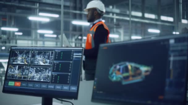 Ingeniero con el ordenador portátil y el trabajo del operador de línea de fábrica de coches en la oficina — Vídeos de Stock