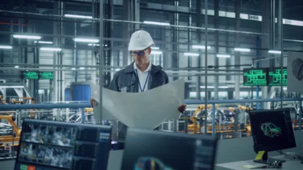 Инженер смотрит на чертеж на автомобильном заводе — стоковое видео