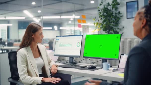 Due colleghi di sesso femminile avendo incontro guardando schermo verde — Video Stock